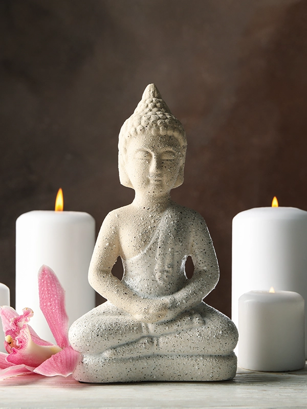 Figura de buda con dos velas blancas.
